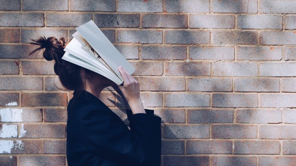 woman with her head in a book - how to improve self-esteem